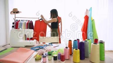 小企业，服装店。 年轻的亚洲妇女在橱窗服装店准备衣服